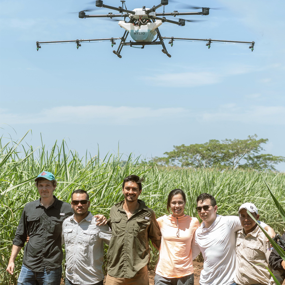 image of hylio team with drone flying overhead