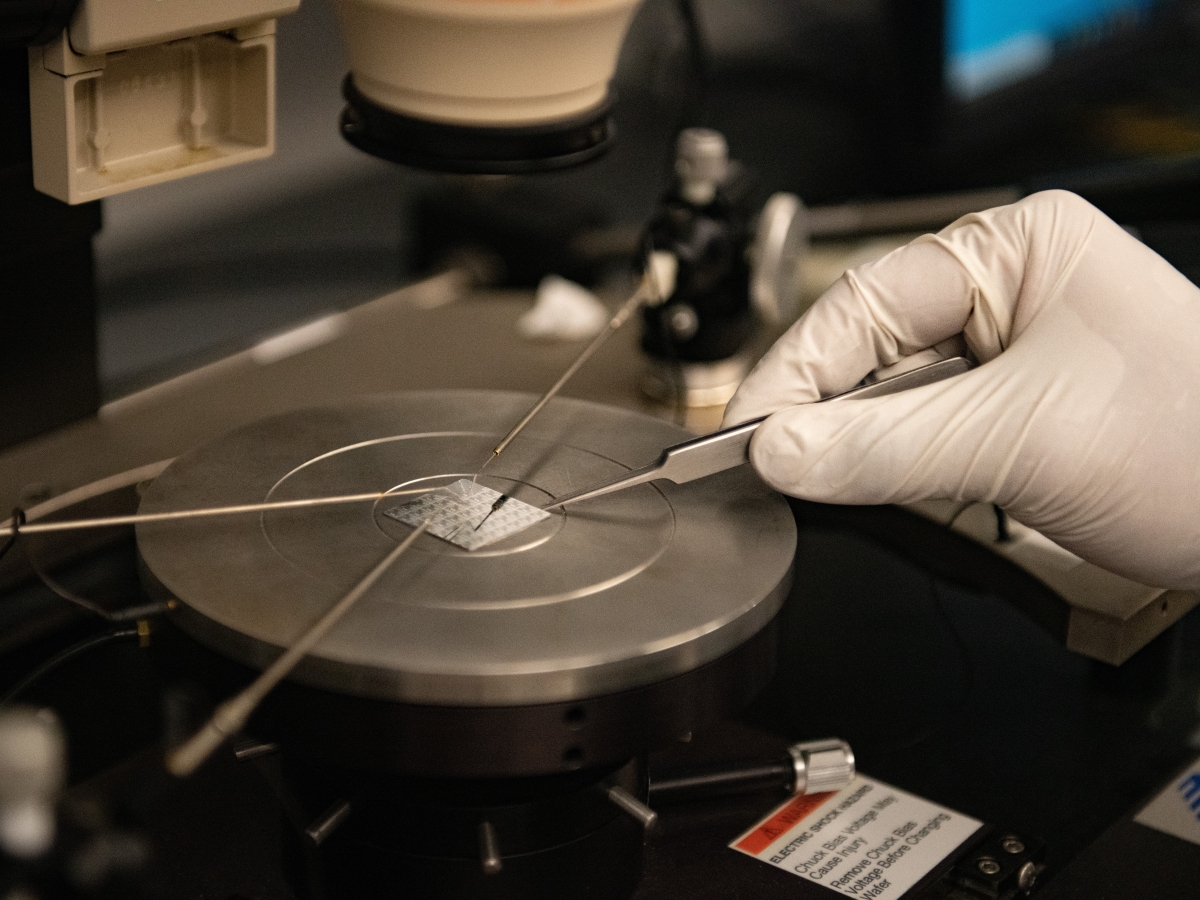 A researcher working on a semiconductor chip in a lab